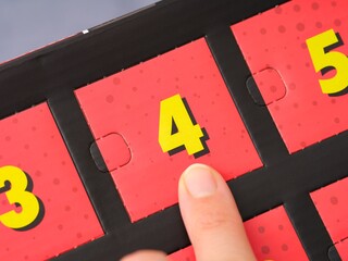 Woman finger pointing at the number 4 on an advent calendar.