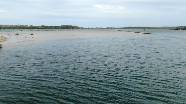 Bellinger River, Urunga, New South Wales in Australia. Aerial forward over shallow waters, low flight, title space