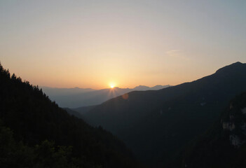 Mountain Sunset Landscape with Silhouetted Peaks and Golden Light