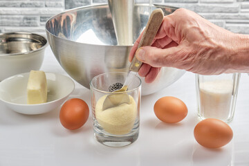 a cook takes semolina from a glass to make pudding