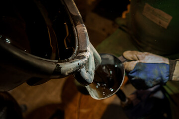 Industrial Worker Pouring Liquid from a Container into a Smaller Vessel