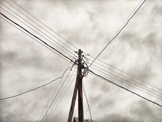 Old pole with wires against the sky. Electric transmission line. Eco-friendly energy