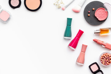 Flat lay of makeup cosmetic products and accessories in brown pink shades, top view. Powder, blush and lipstick