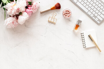 Female workspace with computer and peony flowers, top view