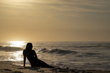Girl silhouette on beach at dawn 1.1