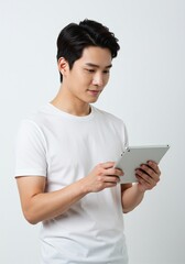 Fototapeta premium Happy young man using digital tablet wearing plain t-shirt isolated on white background . Ai generative 