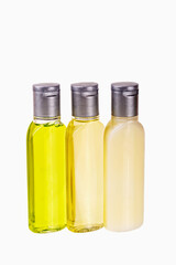 Mockup. Organic cosmetics in three transparent bottles. Essential oils display, natural products for beauty and health, isolated on white. Shampoo, shower gel, body lotion. Travels, tourism, hotels