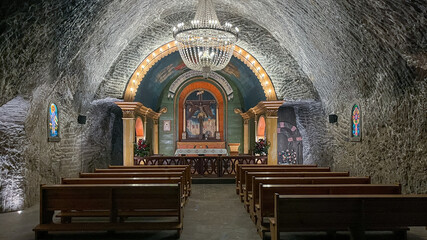 A beautiful underground chapel showcasing intricate architecture with a chandelier, stained glass...