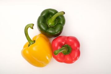 Red, yellow and green peppers on the white background