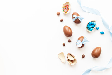 Flat lay of chocolate Easter eggs and candies, top view. Festive concept