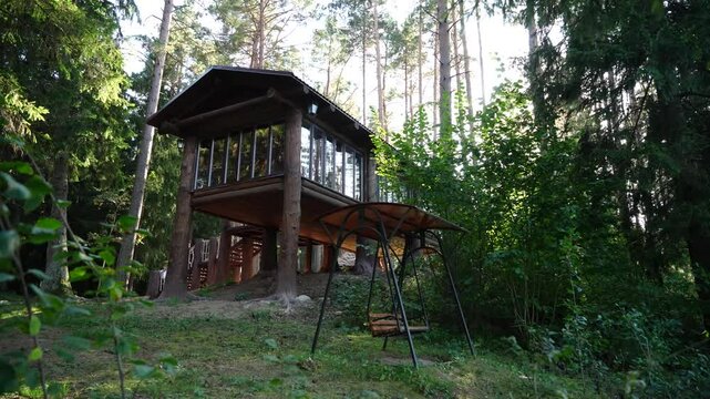 Russia-style wooden cabin house in the woods with swings