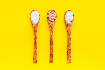 Different kind of sea salt in wooden spoon, top view. Salt for spa, salt baths or cooking