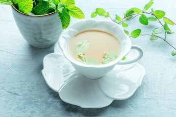 Mint tea. A cup of peppermint tea with fresh mint leaves, on a healthy hot drink