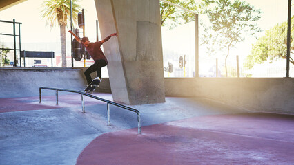 Jump, skateboard and rail with man at park for urban, extreme sports and trick flips. Street league, balance and fitness with person and skating for grind in city with youth, energy and hobby