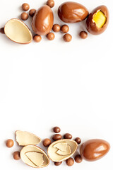 Frame of chocolate eggs and candies, top view. Chocolate background