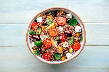 Quinoa salad, healthy Mediterranean lunch with fresh organic vegetables, cheese, and olives, top...