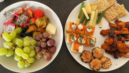 Hors d'oeuvres, Finger food, fancy snacks. Fruits, cheese, dried nuts, crackers and salmon.