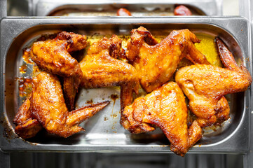 A tray of succulent, golden-brown chicken wings, perfectly cooked and glazed. The appetizing dish is ideal for food lovers and culinary presentations. Perfect for restaurant menus and food blogs.