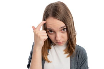 A young woman with long hair pointing at her forehead, looking thoughtful against a white...