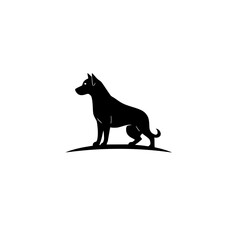 Silhouette of a black dog standing on a tiny mound of grass, looking left.