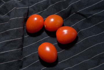 Washed cherry tomatoes on dark blue towel in the kitchen