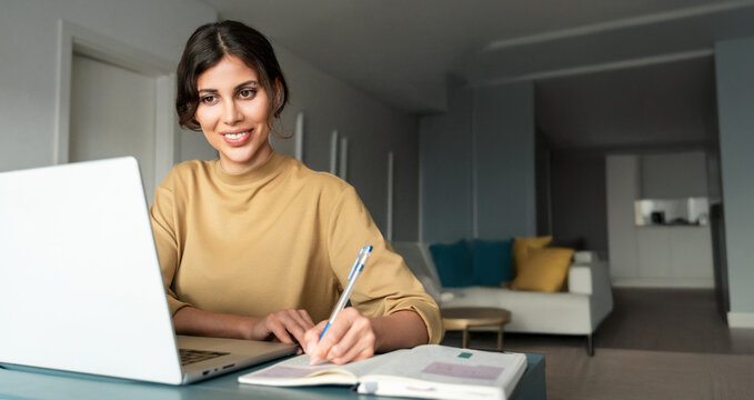 Latin freelance businesswoman entrepreneur using computer AI app for online remote business studying watching webinar. Young smiling student woman working on laptop pc at home. Banner, Copy space