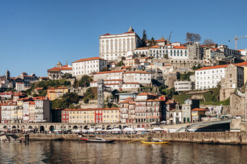 Obraz premium Porto, Portugal - December 28, 2024: View of the Douro River and the picturesque Ribeira district, a UNESCO World Heritage site