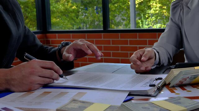 Banker offering loan money for customer and signing a loan contract. Selected focus. 4K