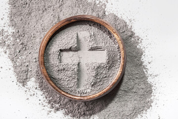 Cross imprint in gray ash on white background. Ash Wednesday