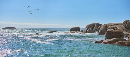 Rocks, birds and blue sky at sea outdoor on holiday, migration and mockup space on banner. Ocean, water and travel with animals flying on vacation in environment, horizon and waves in Australia