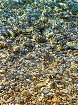 Transparent sea water with pebbles and stones at the bottom. 