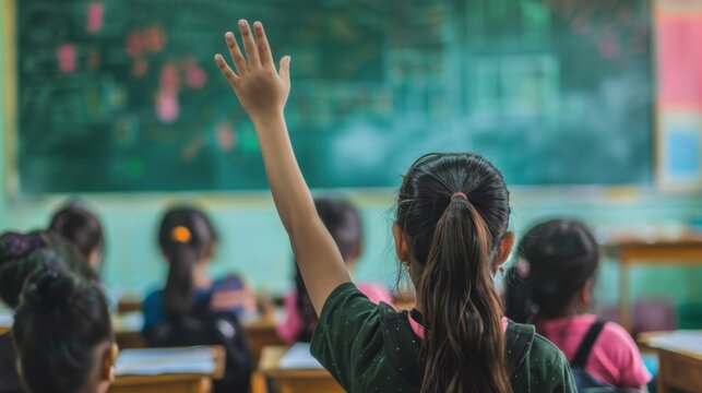 photograph of In the background, a female student raised her hand eagerly to answer a question. in primary school classrooms in India