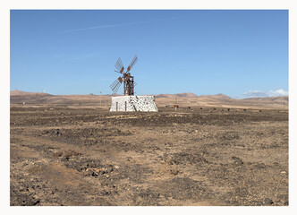 Artistic photo of windmill in bright sunrise light. Las Lajas, Fuertvenetura, Spain