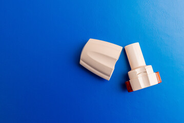 Inhaler or bronchodilator. COPD or Asthma medication instrument a capsule Inhaler on blue...