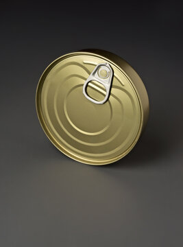 Golden metal food can with pull tab on gray background