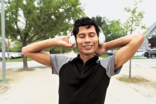 Happy Latino man enjoying music during outdoor workout