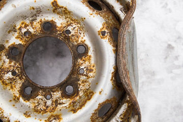 crumpled, rusty car wheel disc