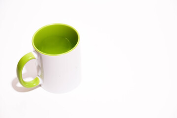 Cup on a white background. Green mug. Green cup or mug isolated on white. Coffee cup. Empty green tea cup. White and green ceramic cup.