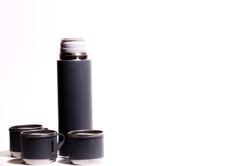 Thermos bottle isolated on white background. Aluminum can. Thermos and metal cups of coffee.