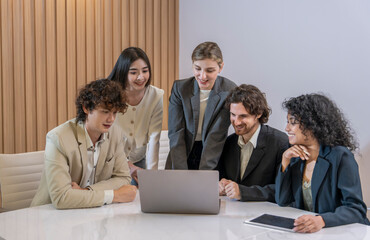 group of multiracial business colleagues meeting in the office,discussing,brainstorming with laptop on desk in a conference room.,collaborating happy business people