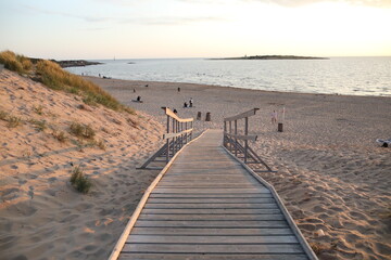 Obraz premium A pier heading down to the beach during sunset