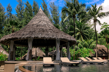 Relaxing tropical retreat in Seychelles featuring thatched huts and serene poolside setting
