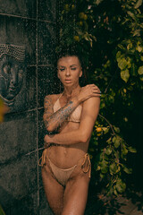 Naklejka premium Tropical Refreshment: Woman Showering in Paradise with Glowing Skin