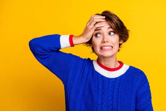 Photo portrait of pretty young girl look nervous empty space dressed stylish blue knitted outfit isolated on yellow color background