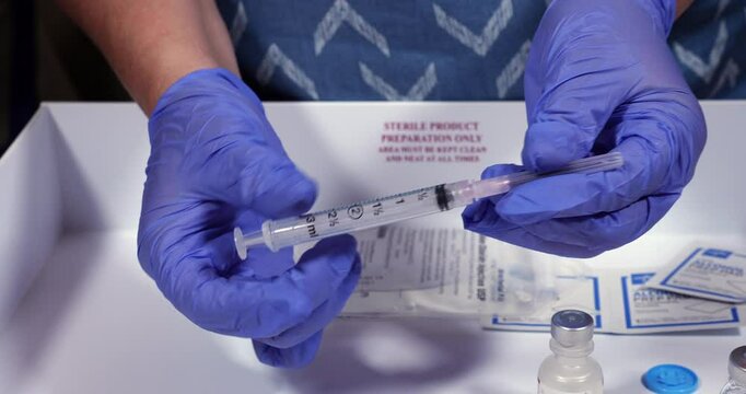 A nurse demonstrates the proper way to recap a used needle/syringe.  	