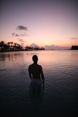 Fototapeta premium Young man in sunset in ocean