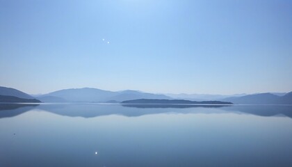 Fototapeta premium Tranquil waters mirroring a bright blue sky, instilling peace.