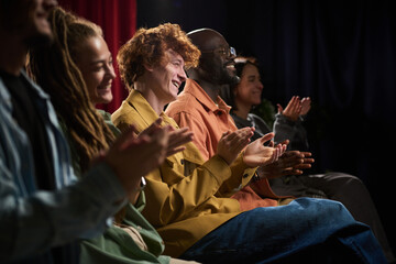 People of various backgrounds engaging in enthusiastic clapping during an event, showcasing joy and...