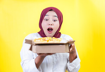 Happy young asian woman in a white shirt and hijab, surprised by delicious pizza delivery