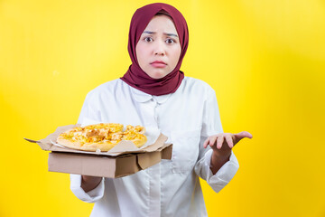an asian woman posing wondered in a white shirt holding a pizza box against a vibrant yellow background
